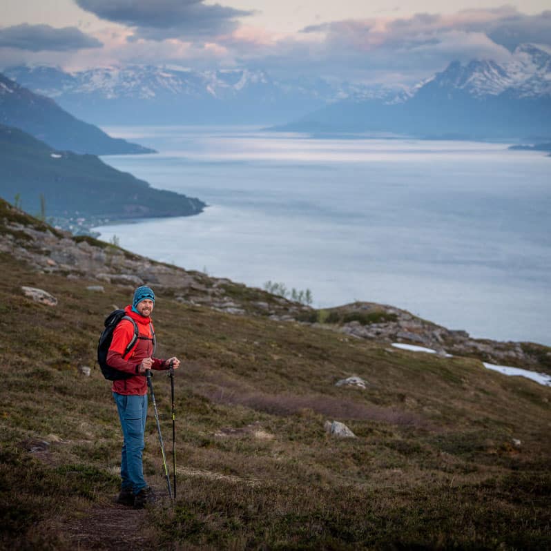 Wanderer am Lyngenfjord mit den Lyngenalpen im Hintergrund